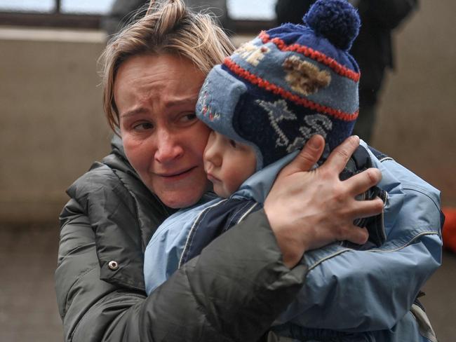 One of the lucky ones. A woman holds her child as she tries to board into a free train to Poland. Russian forces have taken over the Ukrainian city of Kherson. Picture: Daniel Leal