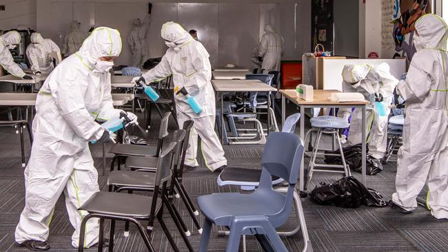 Cleaners disinfect a classroom in a Sydney school. Authorities have reassured parents schools are a safe place for children.