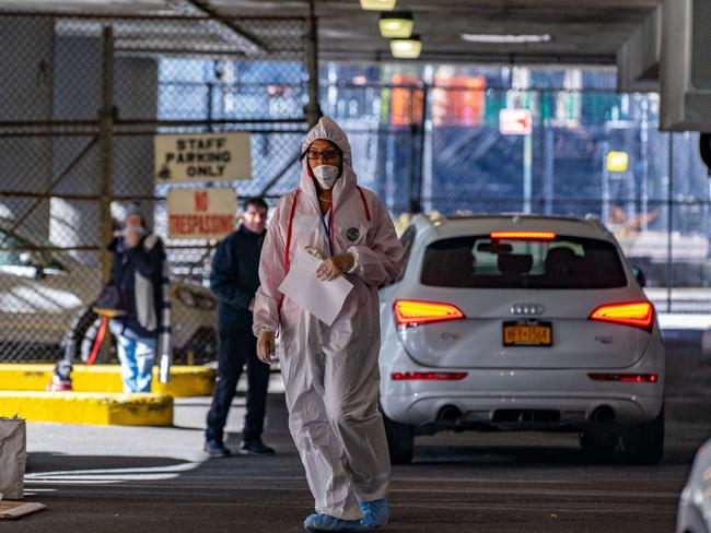 An Animal Medical Center employee wears a hazmat suit as she escorts pets from their owners into the hospital in New York City. Picture: Getty Images/AFP