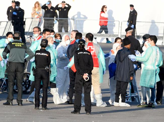 Migrants disembark from the Italian navy boat the Dattilo at the port of Valencia on June 17, 2018.  The first migrants from the Aquarius, which was turned away by Italy and Malta sparking a major migration row in Europe, disembarked in the Spanish port of Valencia. The others will arrive on another Italian navy ship, the Orione, and the Aquarius itself by noon, regional authorities said.  / AFP PHOTO / JOSE JORDAN