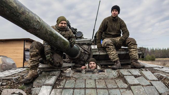 Ukrainian servicemen pose on a T-80 tank in an undisclosed location in eastern Ukraine on Thursday. Picture: AFP