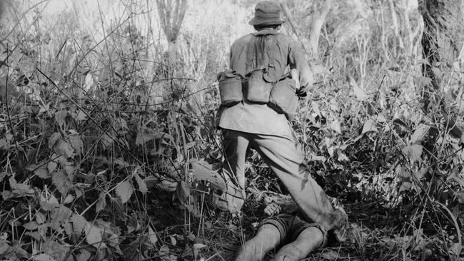 A Digger steps over the dead Vietcong in 1968. Picture: Bill Errington