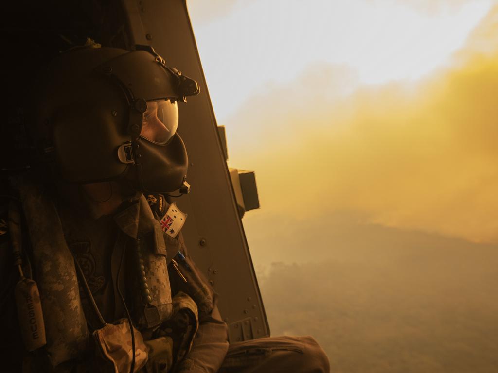 Royal Australian Navy Aircrewman Leading Seaman Ben Nixon of 808 Squadron, assesses the Tianjara Fire in the Moreton and Jerrawangala National Parks out of an MRH90 Taipan Military Support Helicopter. Picture: ADF