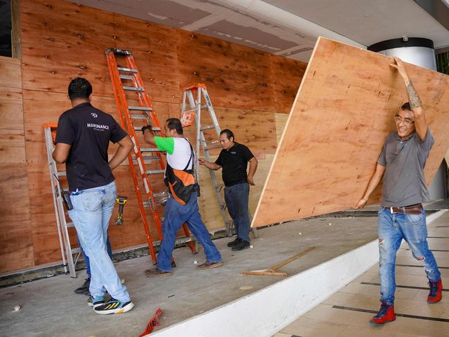 Workers place sheets of wood over windows and glass doors to protect them from the strong winds expected with the arrival of Hurricane Milton. Picture: AFP