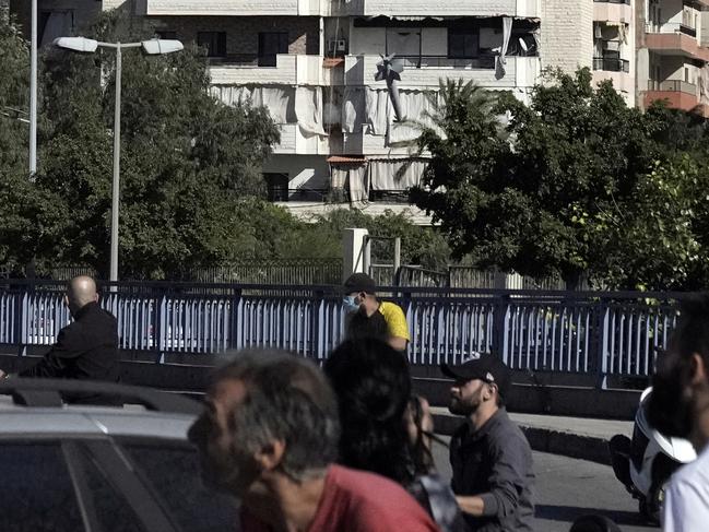 People duck down as a missile launched from an Israeli jet hits a building in Beirut. Picture: Bilal Hussein