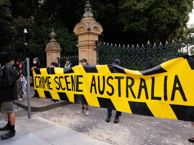 A small protest outside Government House gates before the flag raising ceremony. Picture: NewsWire