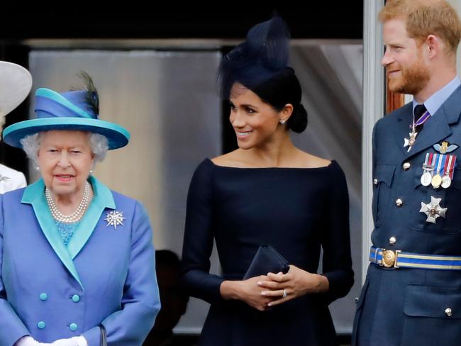 (FILES) In this file photo taken on July 10, 2018 (L-R) Britain's Queen Elizabeth II, Meghan, Duchess of Sussex, Britain's Prince Harry, Duke of Sussex stand on the balcony of Buckingham Palace in London to watch a military fly-past to mark the centenary of the Royal Air Force (RAF). - Britain's Queen Elizabeth II on January 13, 2020, said Prince Harry and his wife Meghan would be allowed to split their time between Britain and Canada while their future is finalised. The couple said last week they wanted to step back from the royal frontline, catching the family off guard and forcing the monarch to convene crisis talks about the pair's future roles. (Photo by Tolga AKMEN / AFP)