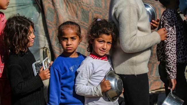 Displaced Palestinians line up to receive food in Rafah, Gaza.