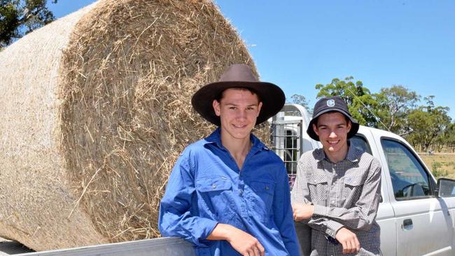 Hayden, 15, (left) and Riley Doherty, 17, were on hand to help their dad Kieran pick up hay donated by Warwick business Olsens Produce this morning. Picture: Elyse Wurm