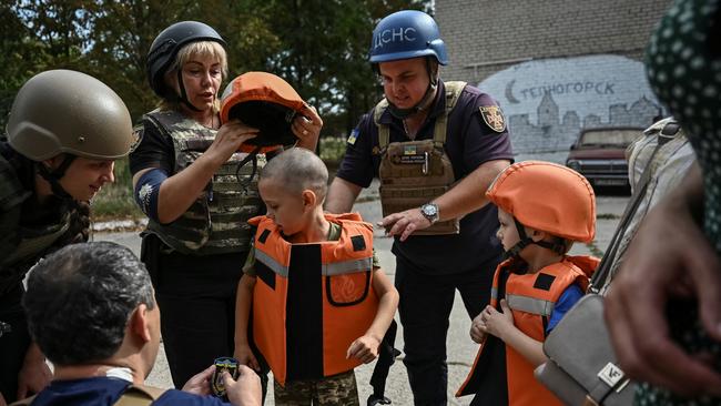 Police put body armour on children before their evacuation from the village of Stepnohirsk near the frontline in the Zaporizhzhia region. Picture: Reuters