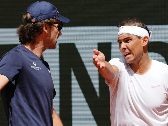 TOPSHOT - Spain's Rafael Nadal (R) speaks with his coach Carlos Moya during a practice session ahead of The French Open tennis tournament on Court Philippe-Chatrier at The Roland Garros Complex in Paris on May 21, 2024. (Photo by Dimitar DILKOFF / AFP)