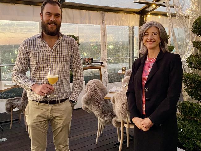 Chief Public Health Officer Professor Nicola Spurrier social distancing at the 2KW bar in June with assistant venue manager Aidan Shaw who is holding the "Nicola Spurrier" gin cocktail created in her honour. Picture: 2KW