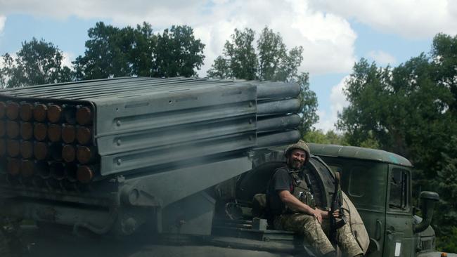 A Ukrainian soldier smiles as he sits on Grad BM-21 multiple rocket launcher at the front line between Russian and Ukraine forces in the countryside of the eastern Ukrainian region of Donbas in July. Picture: AFP