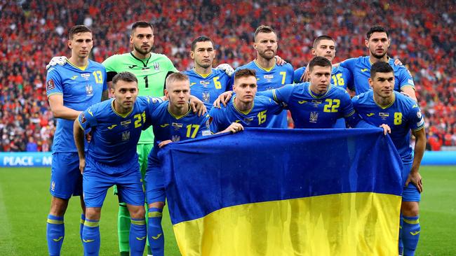 Ukraine players pose for a team photo with their country's flag prior to the FIFA World Cup Qualifier between Wales and Ukraine. (Photo by Michael Steele/Getty Images)