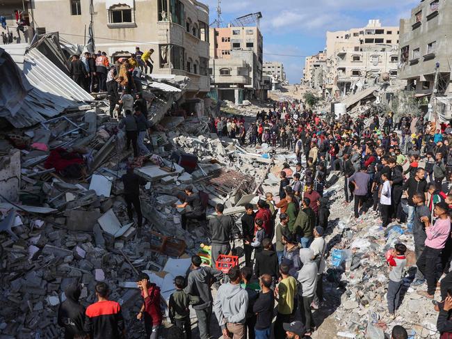 People gather around the rubble of a house destroyed in an Israeli strike as rescuers search for casualties on al-Jalaa street in central Gaza City. Picture: AFP