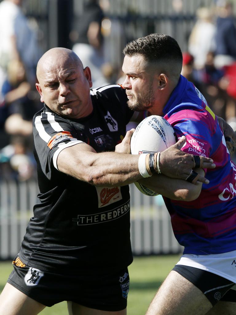 Redfern's Christopher Carr tackles Alexandria's Jayden Riley. Picture: John Appleyard