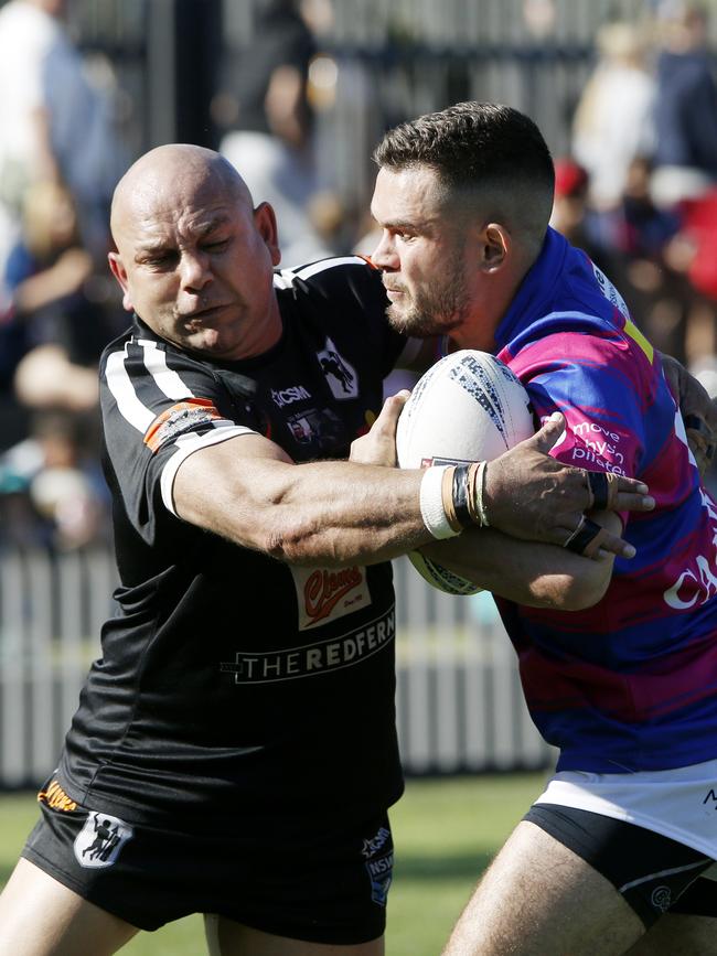 Redfern's Christopher Carr tackles Alexandria's Jayden Riley. Picture: John Appleyard