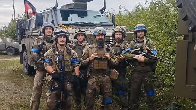 Ukrainian soldiers in front of an Australian Bushmaster.