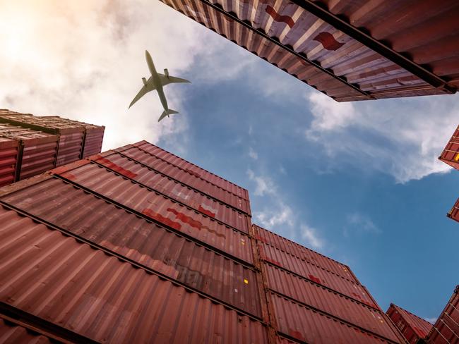 Airplane flying above container logistic. Cargo and shipping business. Container ship for import and export logistic. Logistic industry from port to port. Container at harbor for truck transport.