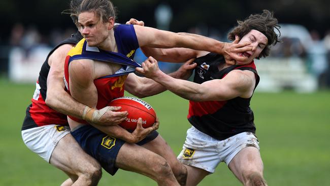 Diggers Rest star Taylor Hine tries to escape the clutches of two Riddell opponents. Picture: Josie Hayden