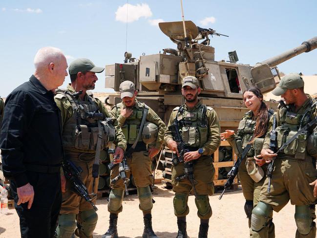 Israeli Defence Minister Yoav Gallant (L) standing with soldiers by a self-propelled artillery howitzer along the border with the Gaza Strip in southern Israel near Rafah. Picture: AFP