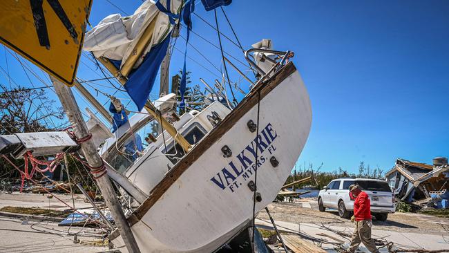 People clear debris in the aftermath of Hurricane Ian in Fort Myers Beach, Florida. Picture: AFP