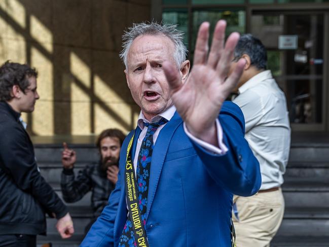 Patrick Lennon shows his displeasure at a photographer’s attention outside Melbourne Magistrates’ Court. Picture: Jake Nowakowski