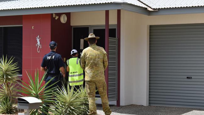 A Public Health environmental health officer, NT Police officer and an Australian Defence Force member check in on those self isolating to ensure they are following quarantine regulations. Picture: Will Zwar