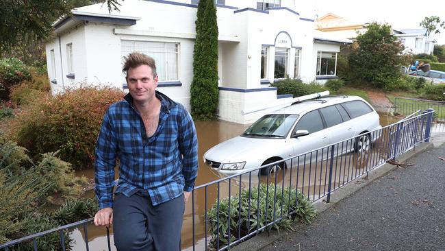 Tom Murray with his submerged car in Sandy Bay Rd in Lower Sandy Bay. Picture: SAM ROSEWARNE