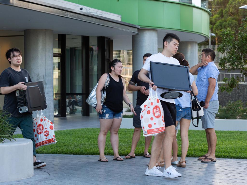 Residents flee the damaged Opal Tower with their belongings last week. Picture: Supplied