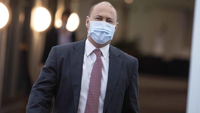 Treasurer Josh Frydenberg walks through the halls of Parliament House in a face mask the day after his statement on the economy. Picture: Gary Ramage.