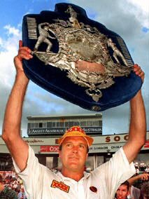 A satisfied Carl Rackemann holds aloft the Sheffield Shield after winning against SA. – sport cricket trophy