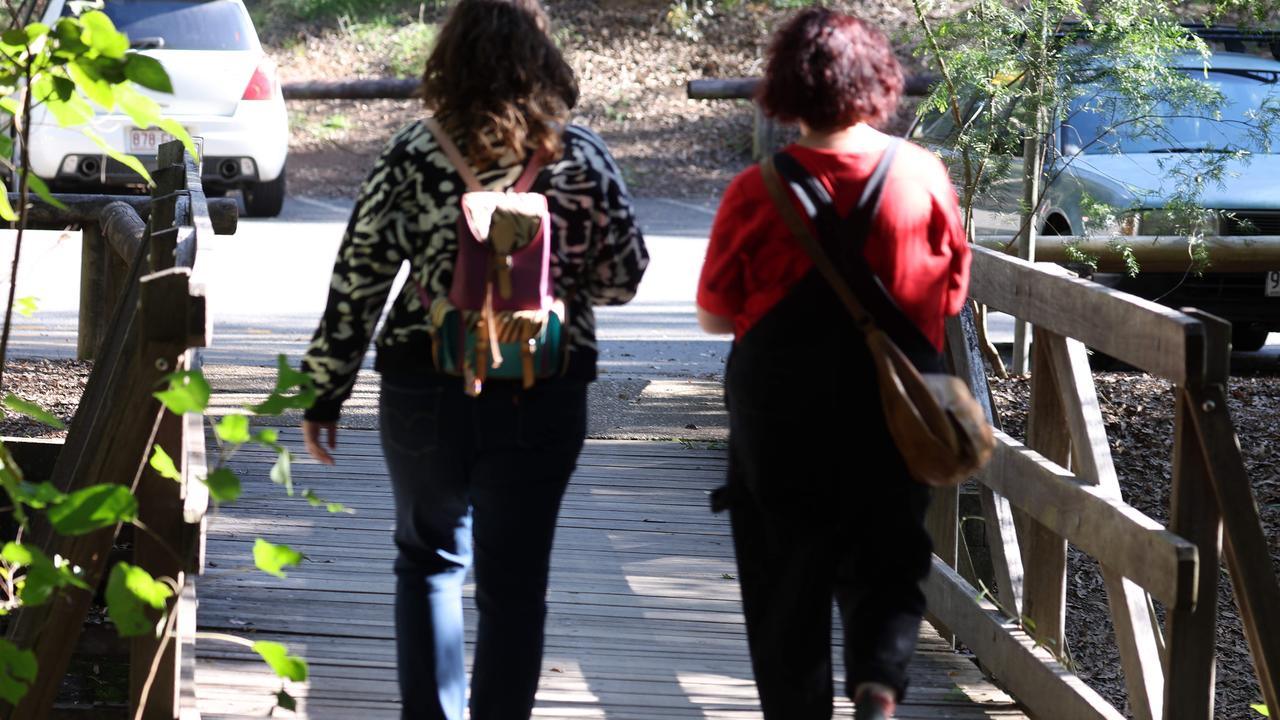 Two female walkers return to their car after hear about the attempted sexual assault on the Cockatoo Trail, Mt Coot-Tha. Picture: Liam Kidston