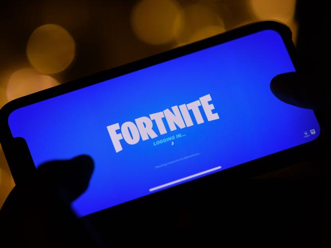 (FILES) This file illustration photo taken on August 14, 2020 shows a person logging into Epic Games' Fortnite on their smartphone in Los Angeles. - The maker of video game sensation Fortnite is taunting Apple amid its legal battle with the tech titan, launching a tournament on August 23, 2020 to highlight its war on the App Store fee policy. (Photo by Chris DELMAS / AFP)