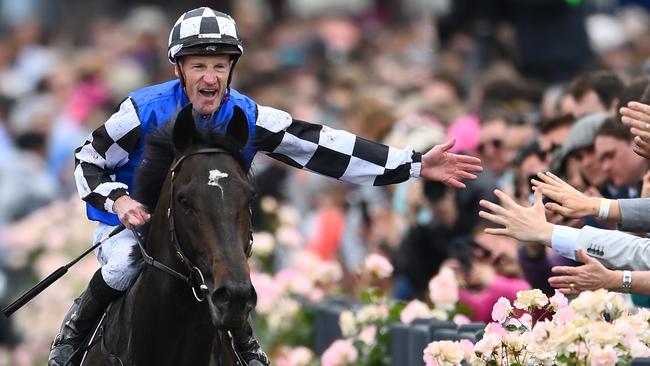 Mark Zahra high gives the Flemington crowd after winning the Melbourne Cup with Gold Trip. Picture: Quinn Rooney-Getty Images