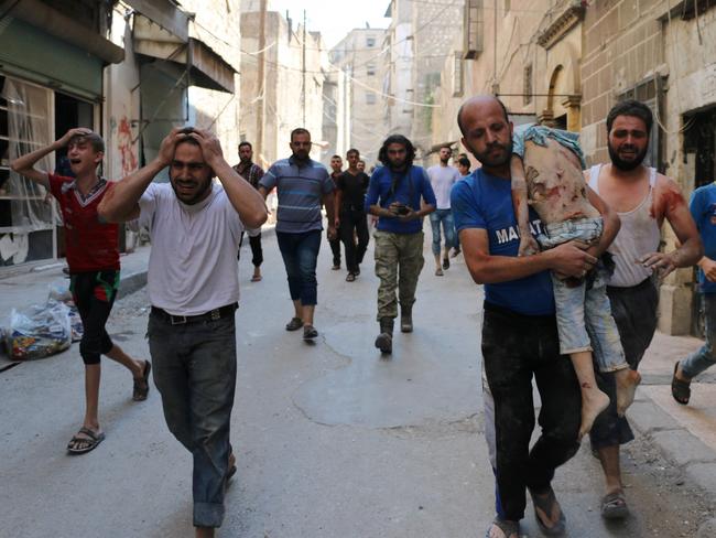 A man carries the body of a child following a reported air strike on the rebel-held Salihin neighbourhood in Aleppo. Picture: Ameer Alhalbi.