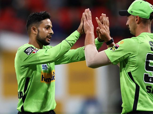 SYDNEY, AUSTRALIA - DECEMBER 12: Tanveer Sangha of the Thunder celebrates with Daniel Sams of the Thunder after dismissing Marcus Stoinis of the Stars during the Men's Big Bash League match between the Sydney Thunder and the Melbourne Stars at GIANTS Stadium, on December 12, 2021, in Sydney, Australia. (Photo by Cameron Spencer/Getty Images)