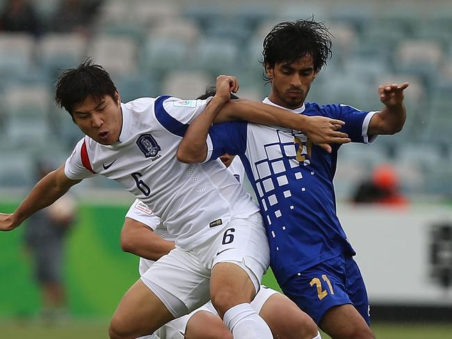 Park Joo Ho of Korea Republic and Ali Almaqseed of Kuwait contest possession during their 2015 Asian Cup match in Canberra.