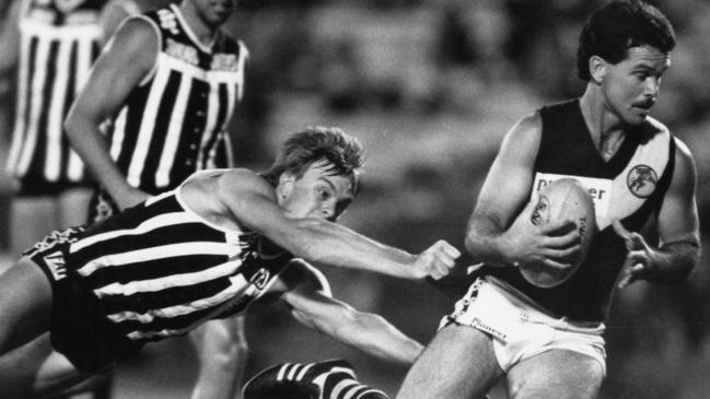 Ross Gibbs of Glenelg eludes a diving Brent Chalmers of Port Adelaide at Football Park in 1991.