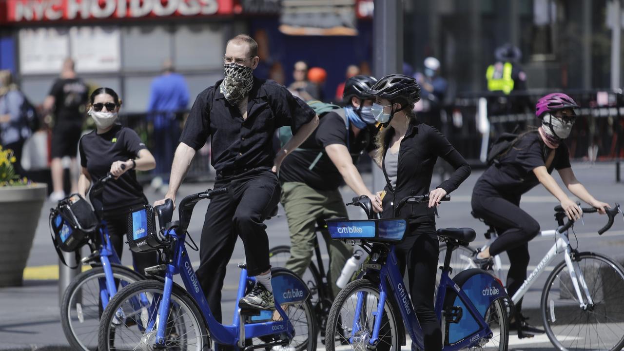 Cyclists wearing protective masks ride through Times Square, Saturday, April 25, 2020, in New York. Picture: AP /Frank Franklin II.