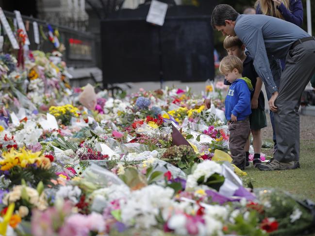 Mourners lay flowers on a wall at the Botanical Gardens in Christchurch, New Zealand. Picture: AP