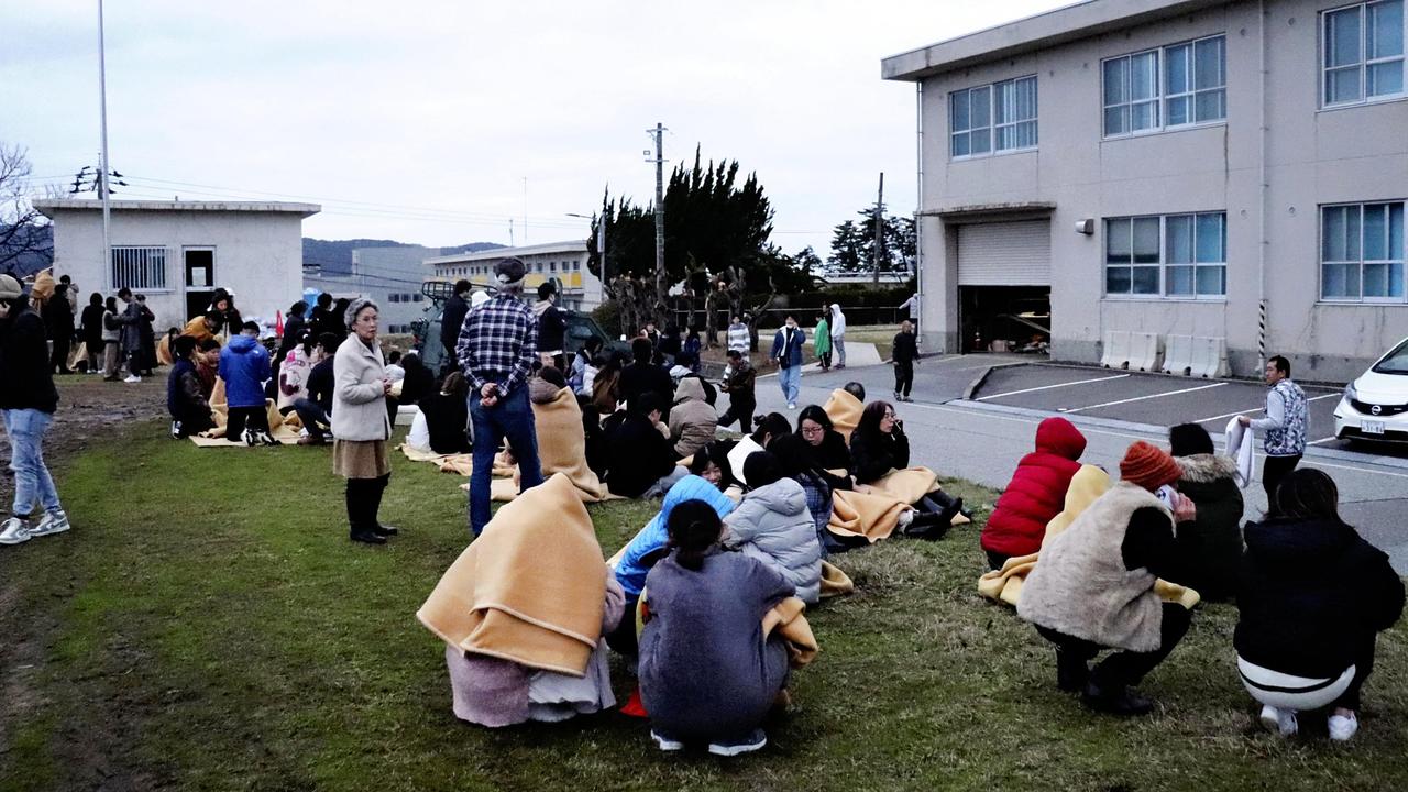 People sit outside in the open after evacuating from buildings in the city of Wajima, Ishikawa prefecture. Picture: Yusuke FUKUHARA / Yomiuri Shimbun / AFP