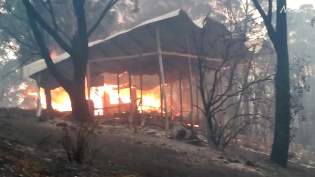 Video shot by Tathra resident David Neyle shows the flames consuming several buildings as it moves in. Picture: David Neyle