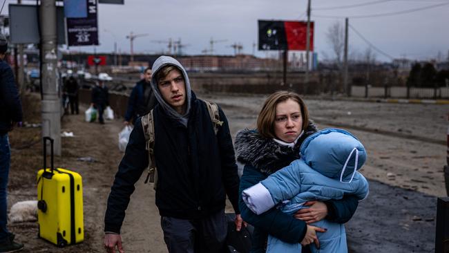 A woman carries her child as they flee the city of Irpin, northwest of Kyiv. Picture: AFP