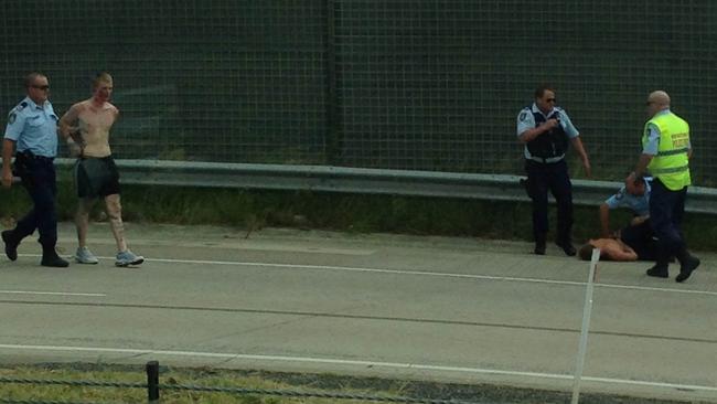 Police arrest two men who allegedly carjacked three vehicles and shot at motorists during a dramatic 150km chase which ended at Tweed Heads yesterday. Photo: Luke Kuhnell