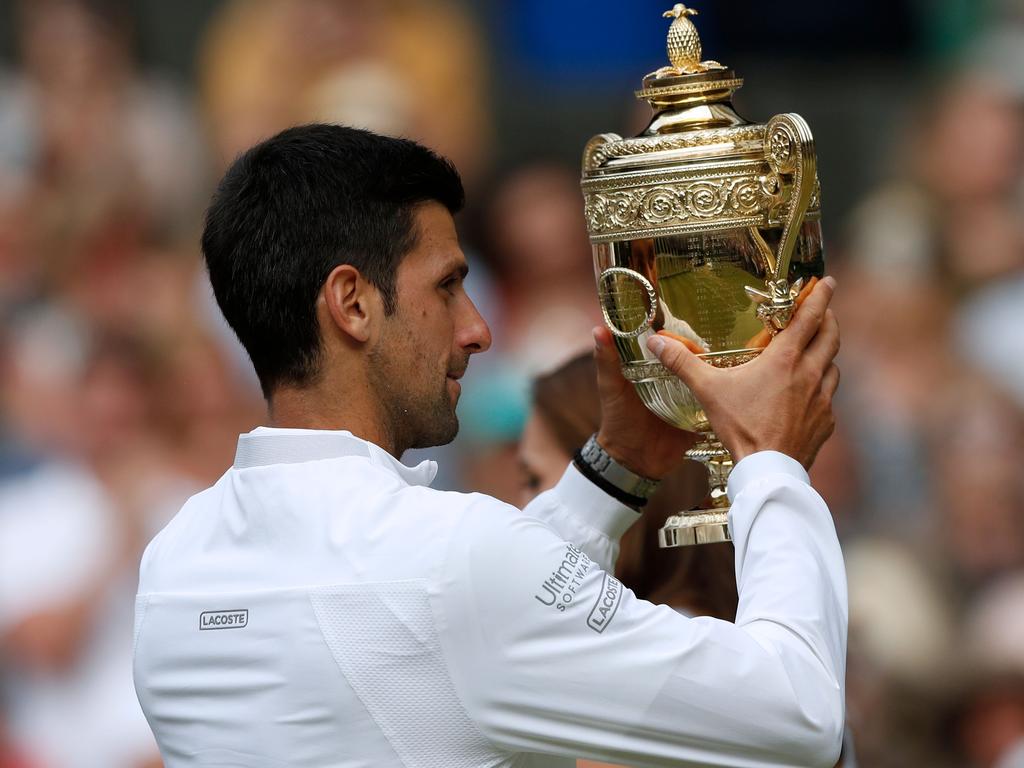 Serbia's Novak Djokovic holds the winner's trophy. (Photo by Adrian DENNIS / POOL / AFP)