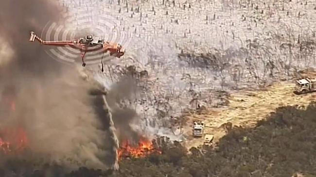 A firefighting helicopter douses a blaze on Kangaroo Island. Picture: Seven News