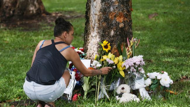 The scene of a fatal traffic crash at Manoora, where an allegedly stolen Toyota Yaris left Pease Street near the Saltwater Creek bridge and crash into a tree. Denise Weazael of Manoora lays some flowers at the scene of the crash. Picture: Brendan Radke