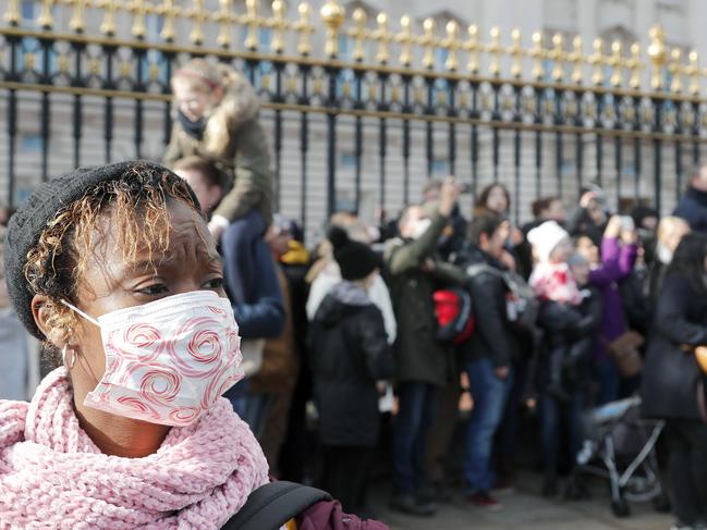 Many tourists outside Buckingham Palace sported masks. Picture: AP