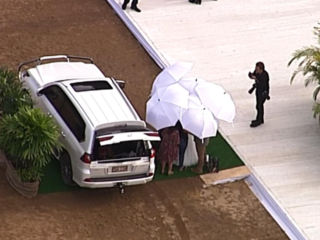 Bindi is shielded by umbrellas. Picture: 7News